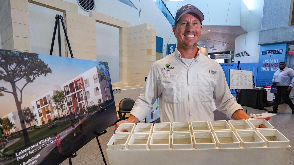 Brett Perry of RENCO USA holds up a composite building module, one of the innovative products and methods on display at the Building Blocks Housing Summit, hosted by Miami-Dade Mayor Daniela Levine Cava, at loanDepot park, on June 30, 2022.
