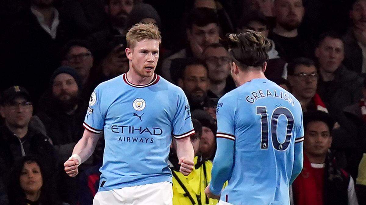 Los jugadores de Manchester City Kevin De Bruyne (izq.) y Jack Grealish celebran tras un gol del mediocampista belga ante el Real Madrid, en el partido de ida de la semifinal de la Liga de Campeones, celebrado el 10 de mayo de 2023 en Madrid.