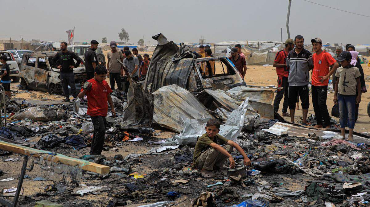 (240527) -- GAZA, May 27, 2024 (Xinhua) -- Palestinians are seen at the site of an Israeli airstrike on tents for displaced people near the southern Gaza Strip city of Rafah, on May 27, 2024. At least 45 Palestinians, including children and women, were killed in Israeli airstrikes on tents for displaced people near Rafah city, Gaza’s health authorities said in a press statement on Monday. (Photo by Rizek Abdeljawad/Xinhua) (Photo by Xinhua/Sipa USA)