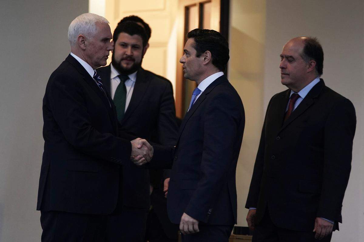 El vicepresidente Mike Pence (izq) le estrecha la mano a Carlos Vecchio (tercero desde la izquierda), representante del presidente interino venezolano Juan Guaidó, afuera de la Casa Blanca tras una reunión el 29 de enero del 2019.