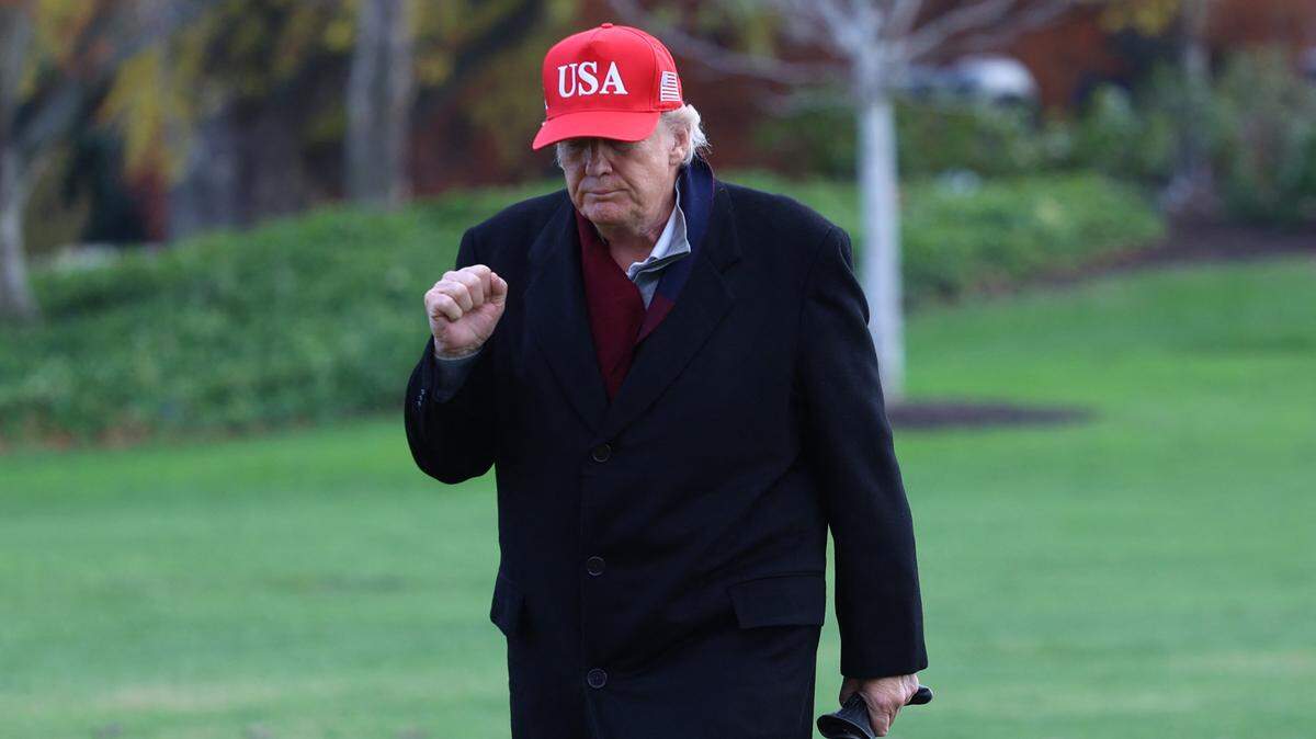 US President Donald Trump raises a fist as he walks from Marine One to the White House after landing on the South Lawn in Washington, DC, on November 22, 2025. Trump is returning to the White House after taking an aerial tour of The Courses at Joint Base Andrews, Maryland. (Photo by Alex WROBLEWSKI / AFP via Getty Images)