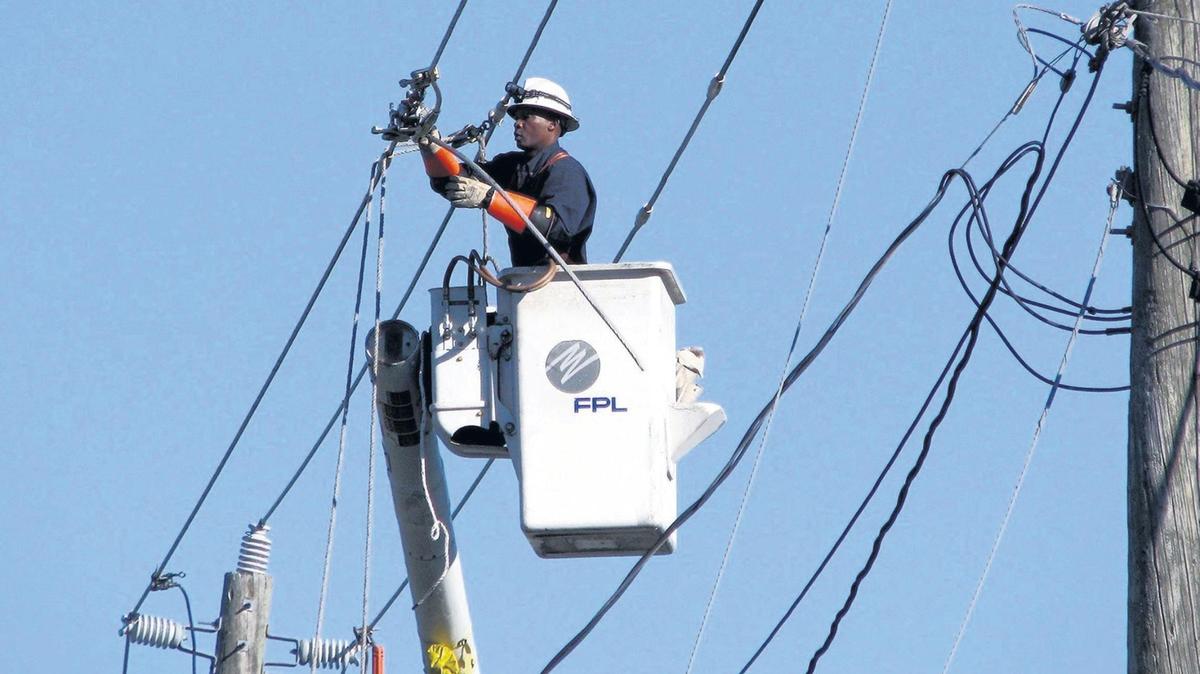 FILE PHOTO - A Florida Power & Light contractor was electrocuted Wednesday while working on a power line in Southwest Miami-Dade. The worker in the photo is not the FPL contractor who died Wednesday.