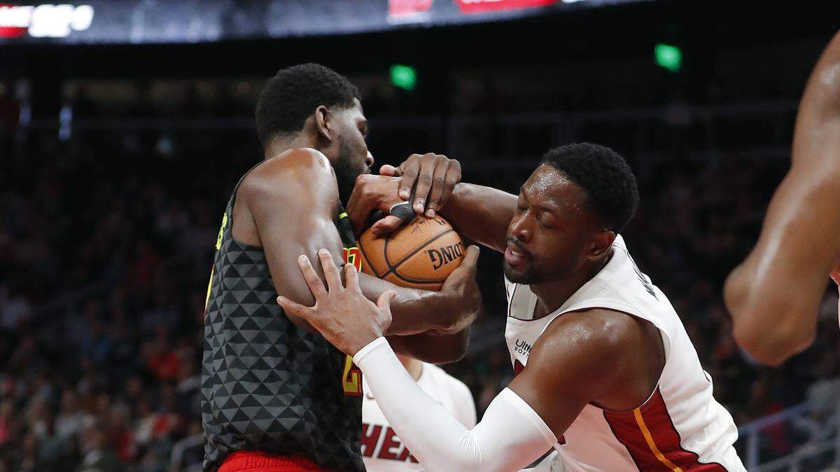 El escolta del Heat Dwyane Wade (der.) y Alex Poythress, de los Hawks, luchan por la pelota en el partido efectuado el 3 de noviembre de 2018 en Atlanta.