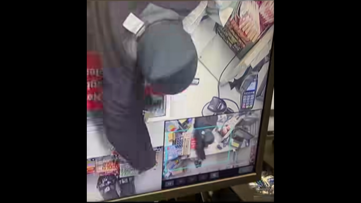 En un video de vigilancia de una tienda Circle K puede verse cuando una mujer mete la mano por detrás del mostrador del cajero y roba gran cantidad de boletos de la lotería.