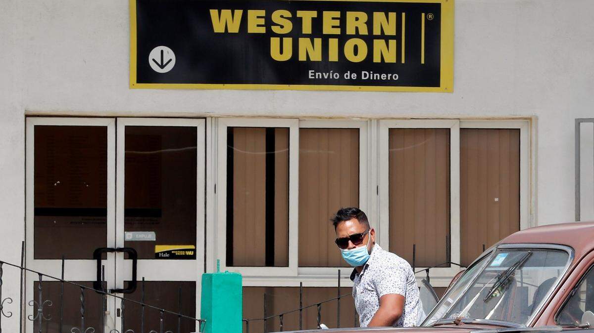 Dos autos clásicos pasan frente a una oficina de Western Union en La Habana, Cuba, el 23 de noviembre de 2020. EFE / Ernesto Mastrascusa/Sipa USA