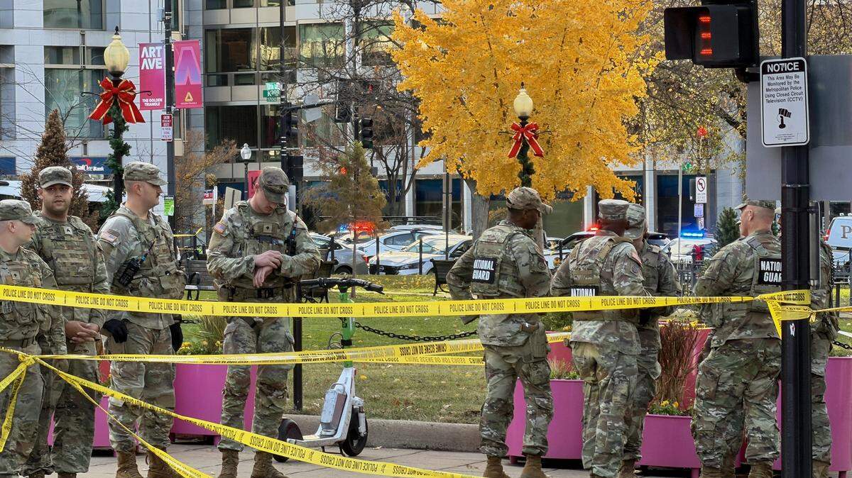 National Guard soldiers gather near a crime scene after a shooting in downtown Washington, DC, on November 26, 2025. Two members of the National Guard were shot Wednesday just blocks from the White House, according to officials, as a spokesperson for Donald Trump said the president has been briefed on the "tragic situation." Police said they had detained a suspect. (Photo by Daniel SLIM / AFP via Getty Images)