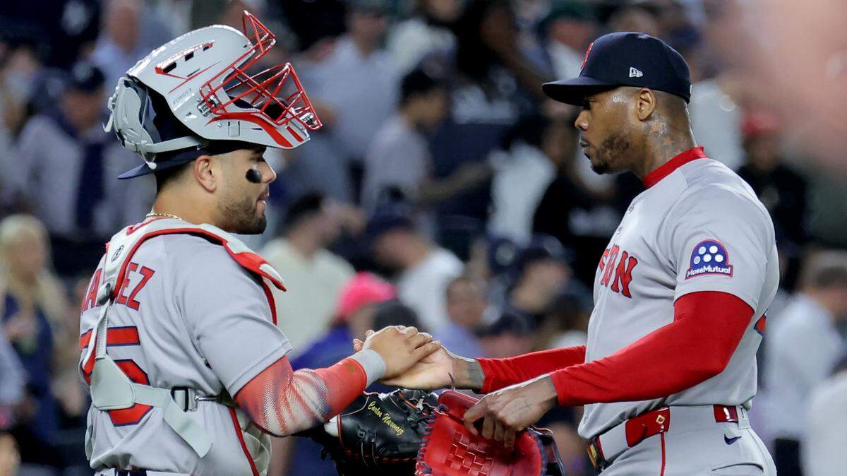 El cerrador de los Medias Rojas Aroldis Chapman (der.) celebra con el receptor Carlos Narváez tras la victoria el martes ante los Yankees en Nueva York, en el primer partido de la Serie de Comodines de la Liga Americana.