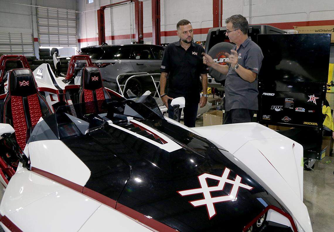 El guru de los carros, Alex Vega, dueño de The Auto Firm, habla con Orelbis Darias (der.),  uno de los técnicos del negocio, dedicado a  personalizar automóviles caros.