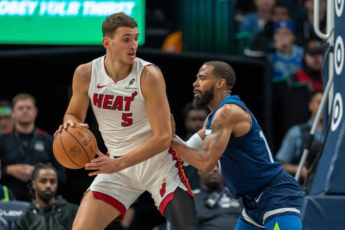 El jugador del Heat de Miami Nikola Jovic (izq.) trata de pasar la marca de Mike Conley, de los Timberwolves, en el partido celebrado el 10 de noviembre de 2024 en Minneapolis, Minnesota.