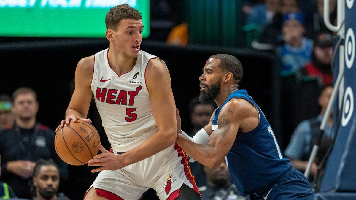 El jugador del Heat de Miami Nikola Jovic (izq.) trata de pasar la marca de Mike Conley, de los Timberwolves, en el partido celebrado el 10 de noviembre de 2024 en Minneapolis, Minnesota.