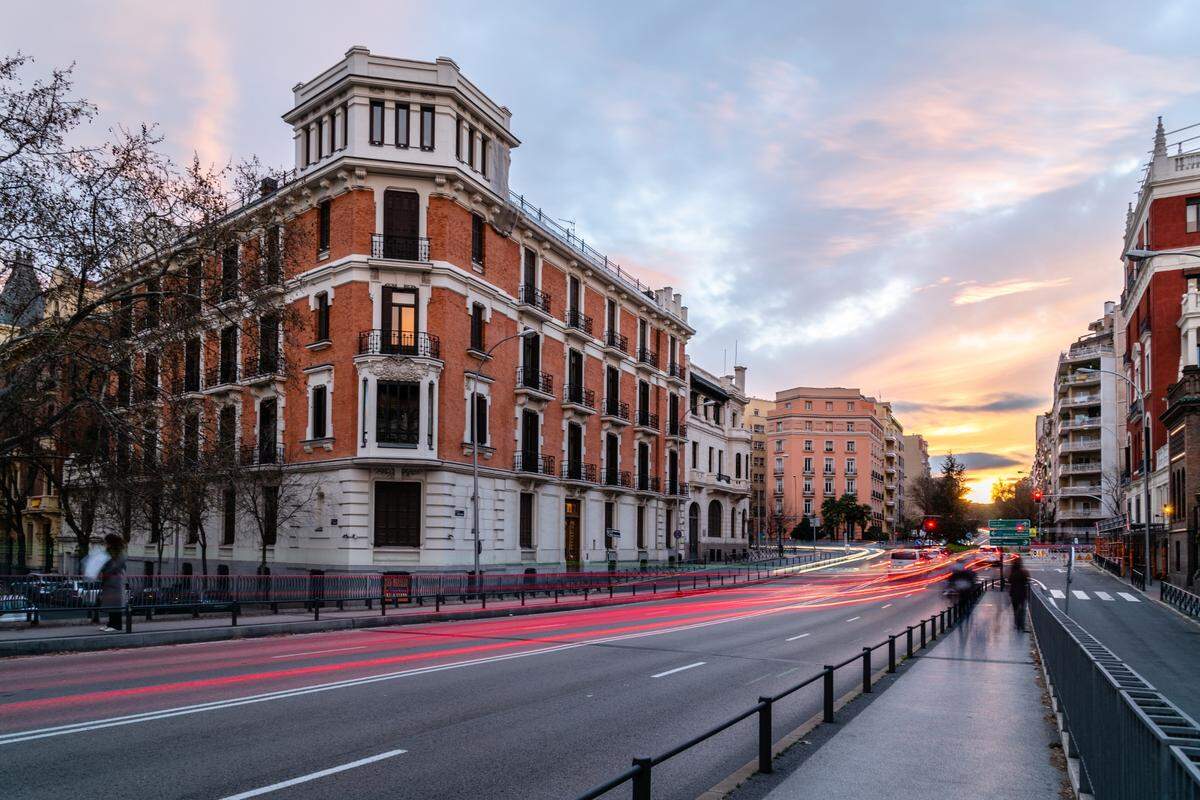 Paisaje urbano de Madrid al atardecer. Puente Juan Bravo sobre la avenida de la Castellana y la plaza de Rubén Darío con estelas de luz de coches.
