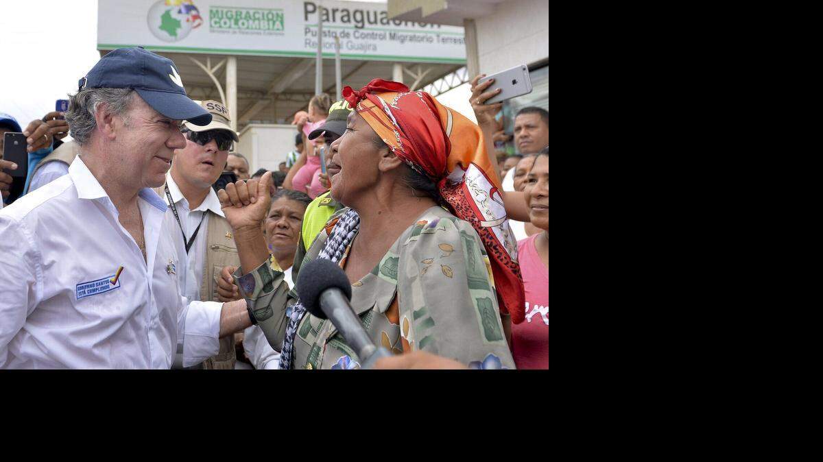 Fotografía cedida por la presidencia de Colombia del mandatario Juan Manuel Santos hablando con residentes del paso fronterizo de Paraguachón (Colombia) el martes 15 de septiembre de 2015, a donde llegó el mandatario después de que fuera cerrada hace una semana por orden de su homólogo venezolano, Nicolás Maduro. 