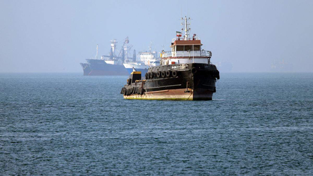 En esta imagen obtenida de la agencia de noticias iraní ISNA el 4 de mayo de 2026, el remolcador de bandera iraní Basim navega cerca de un barco anclado en el estrecho de Ormuz, frente a Bandar Abbas, en el sur de Irán.