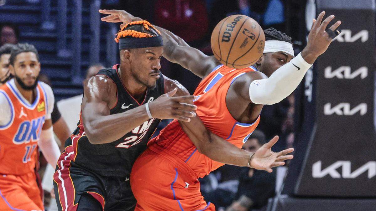 El delantero del Miami Heat, Jimmy Butler (22), pierde el balón ante el escolta del Oklahoma City Thunder, Luguentz Dort (5), durante la primera mitad de un partido de baloncesto de la NBA en el Kaseya Center, Miami, Florida, el viernes 20 de diciembre de 2024.