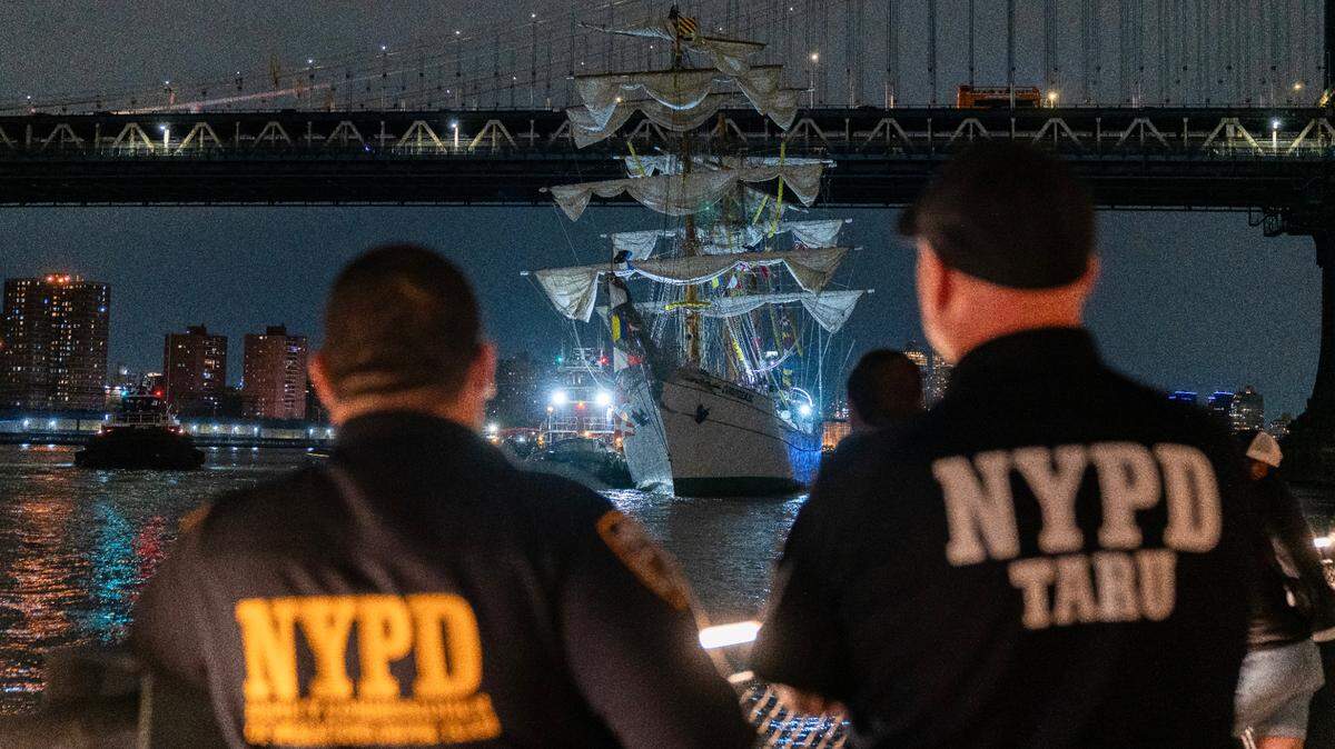 Miembros del Departamento de Policía de Nueva York observan el buque escuela mexicano Cuauhtémoc junto al Puente de Brooklyn en Nueva York, el sábado, el 17 de mayo de 2025.