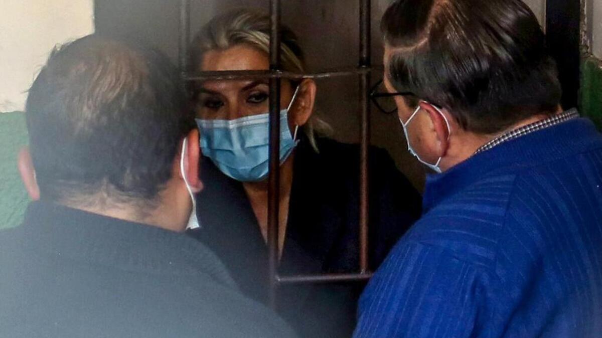 Tras las rejas, la ex presidenta interina de Bolivia, Jeanine Anez, habla con sus abogados en la cárcel de una estación de policía, en La Paz, Bolivia, el sábado 13 de marzo de 2021. 