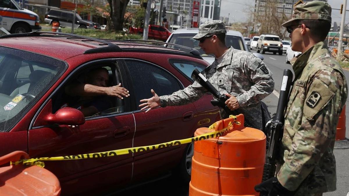 San Juan, Puerto Rico, septiembre 28: Los especialistas de la Guardia Nacional de Puerto Rico David Sanchez e Ismael Segarra ayudan a controlar la situación en una línea de vehículos para echar gasolina, después del paso de María.