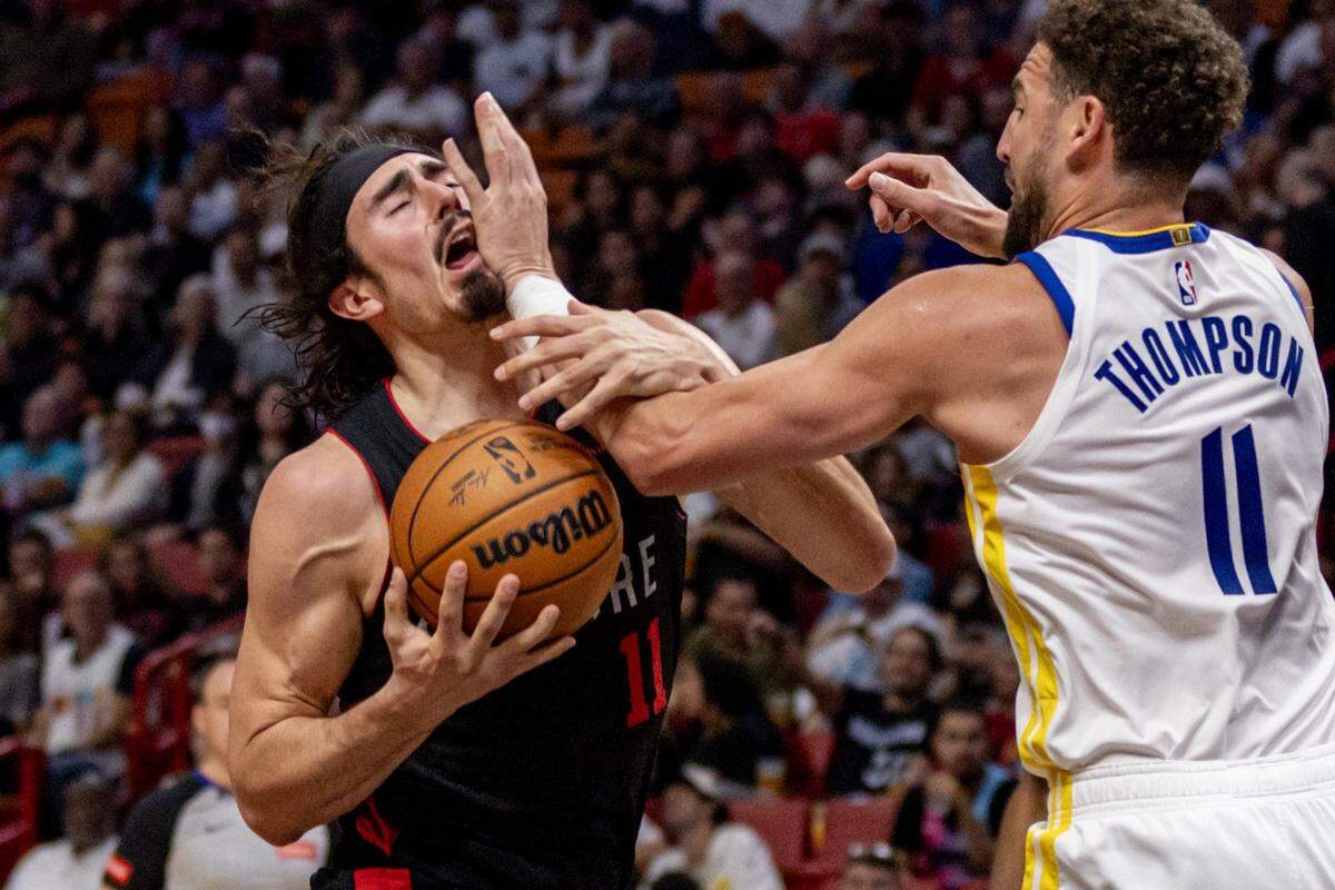 El jugador del Heat Jaime Jáquez Jr. (izq.) recibe una falta de Klay Thompson, de los Warriors de Golden State, en el partido celebrado el 26 de marzo de 2024 en Miami.