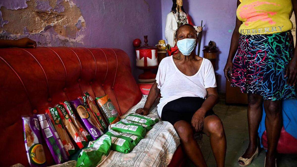 Una mujer cubana muestra un módulo de alimentos en su casa del municipio de Arroyo Naranjo en La Habana, el 11 de agosto de 2021. Muchas veces, familiares de Miami ayudan.