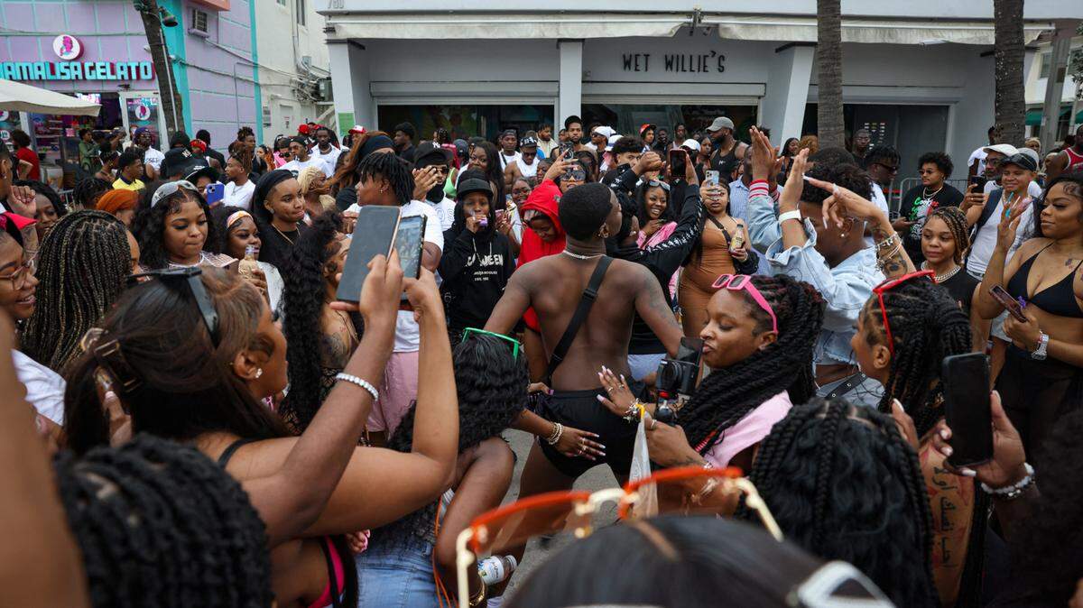 Keandre Reese, centro, baila en medio de una multitud de Spring Breakers frente a Wet Willies el domingo 19 de marzo de 2023 en Ocean Drive en Miami Beach.