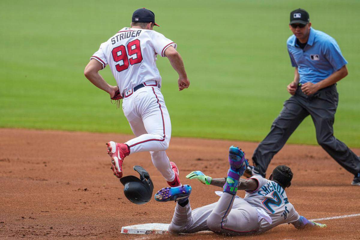 El jardinero de los Marlins Jazz Chisholm Jr. trata de llegar quieto a primera base ante la asistencia del abridor de los Bravos Spencer Strider, en el partido celebrado el 2 de julio de 2023 en Atlanta.