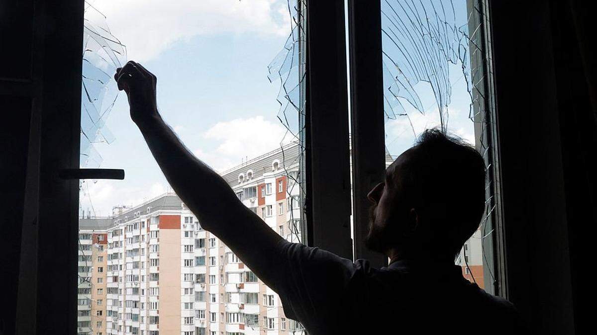 Un residente retira fragmentos de vidrio de una ventana rota en un edificio residencial tras un ataque aéreo en Krasnogorsk, región de Moscú, el 17 de mayo de 2026, en medio del conflicto ruso-ucraniano en curso.