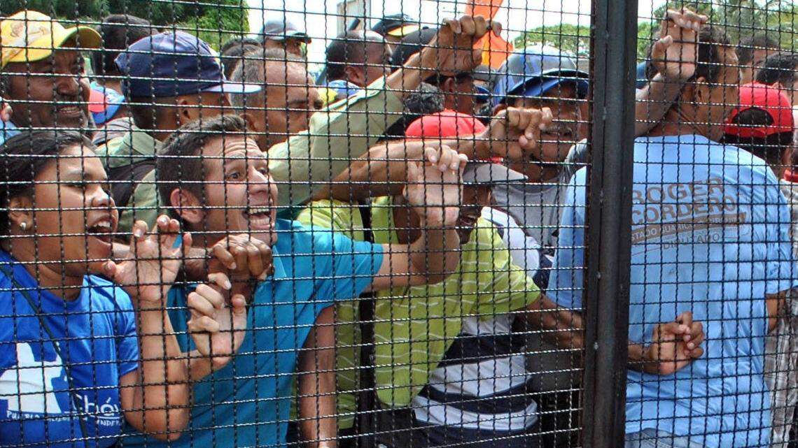 Simpatizantes del mandatario Nicolás Maduro gritan consignas en contra de Lilian Tintori (der.), esposa del opositor venezolano preso Leopoldo López, el miércoles en el estado Guárico, Venezuela.