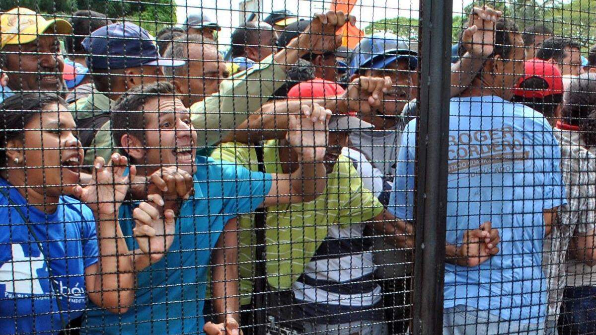 Simpatizantes del mandatario Nicolás Maduro gritan consignas en contra de Lilian Tintori (der.), esposa del opositor venezolano preso Leopoldo López, el miércoles en el estado Guárico, Venezuela.