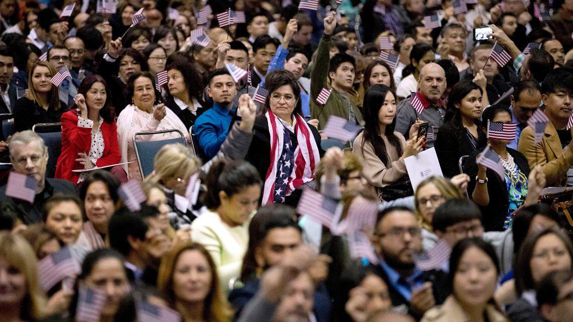 Nuevos inmigrantes ondean banderines de Estados Unidos durante una ceremonia de naturalización en Los Angeles el año pasado.