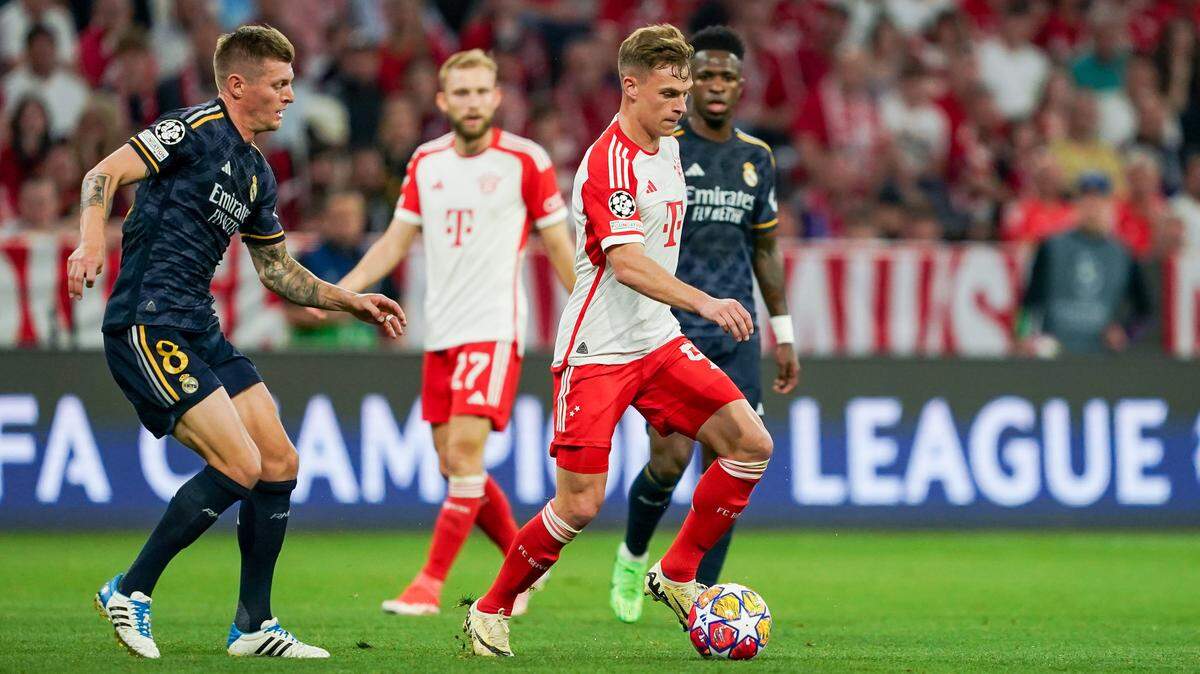 :Joshua Kimmich, del Bayern Munich, conduce el balón entre los jugadores del Real Madrid Toni Kroos y Vinicius Jr en el partido de ida de l semifinalesde la Liga de Campeones de la UEFA, el 30 de abril de 2024, en el Allianz Arena de Munich, Alemania.
