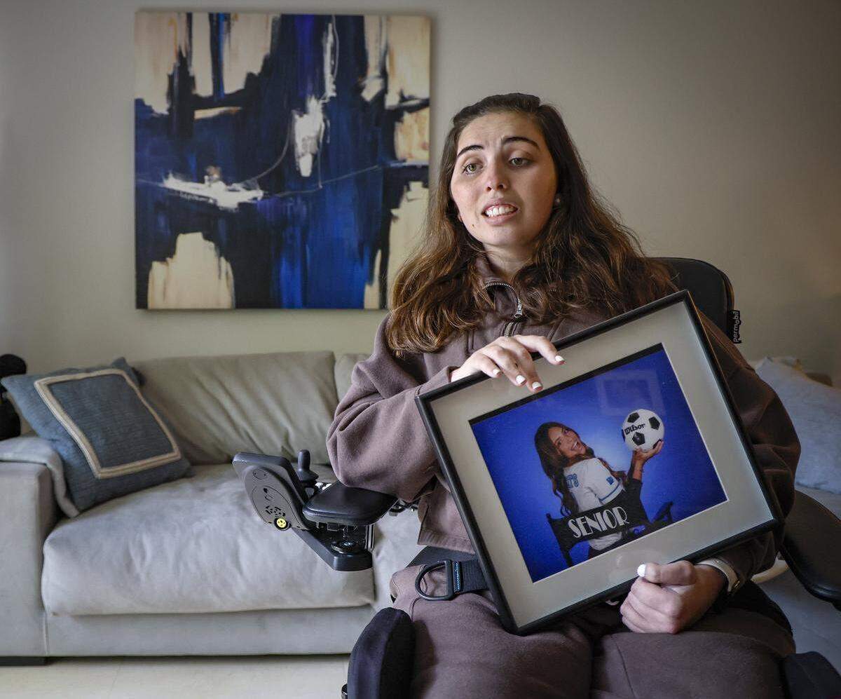 Katerina “Katy” Puig sostiene un retrato de su último año en la Academia Our Lady of Lourdes, en su hogar en Miami, el miércoles 15 de octubre de 2025. Puig aún se recupera de lesiones catastróficas.