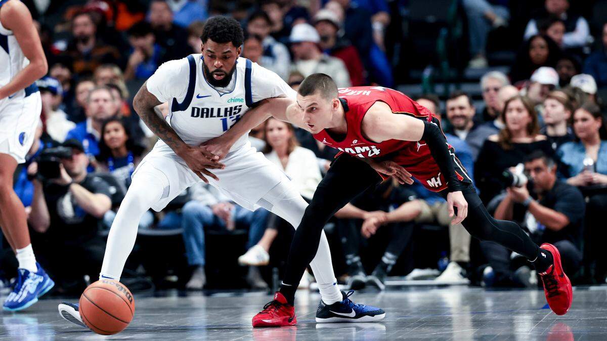 El jugador del Heat de Miami Tyler Herro (der.) lucha por la pelota con Naji Marshall, de los Mavericks, en el partido celebrado el 13 de febrero de 2025 en Dallas.