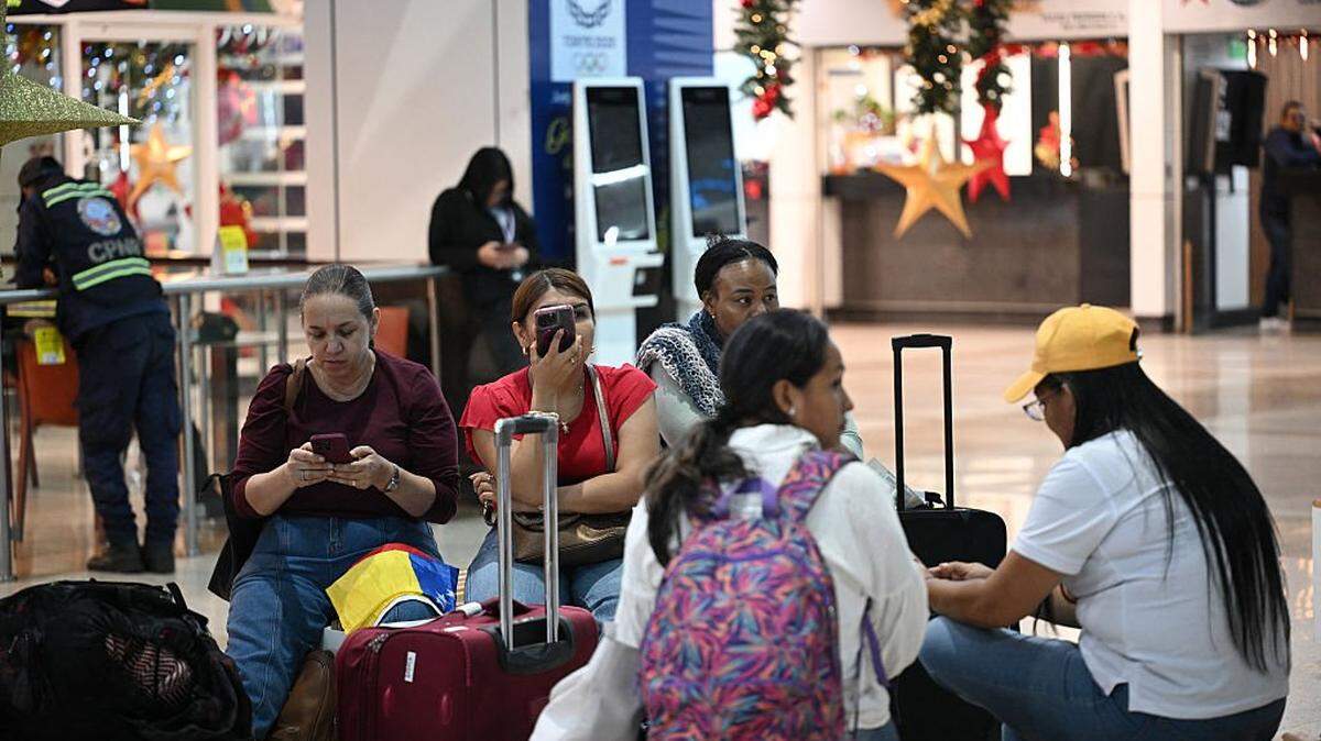 Passengers wait to board their flight at Simon Bolivar International Airport in Maiquetia, La Guaira State, Venezuela, on November 27, 2025. Venezuela's decision to ban foreign airlines that stopped flying to the Caribbean country over concerns about US military activity was branded "disproportionate" on Thursday as thousands of passengers scrambled to save their travel plans. (Photo by Federico PARRA / AFP via Getty Images)