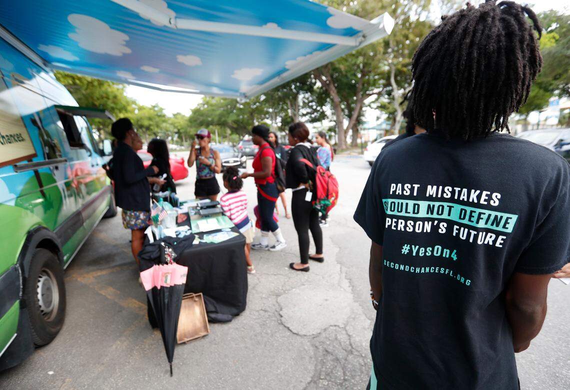 People gather around the Ben & Jerry’s “Yes on 4” truck as they learn about Amendment 4 and eat free ice cream at Charles Hadley Park in Miami in October. Amendment 4, asked voters to restore the voting rights of people with past felony convictions.