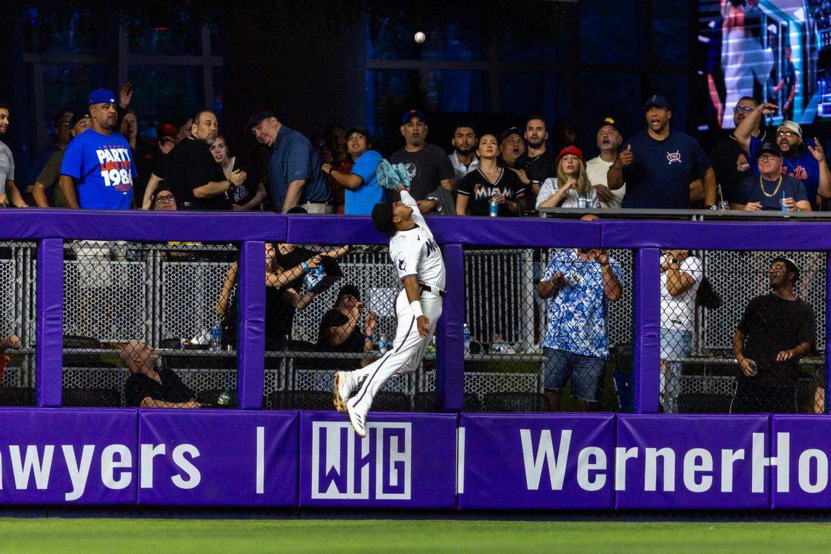 El jardinero de los Marlins Javier Sanoja trata de robarle un jonrón a Starling Marte, de los Mets de Nueva York, en el partido celebrado el 31 de marzo de 2025 en Miami.