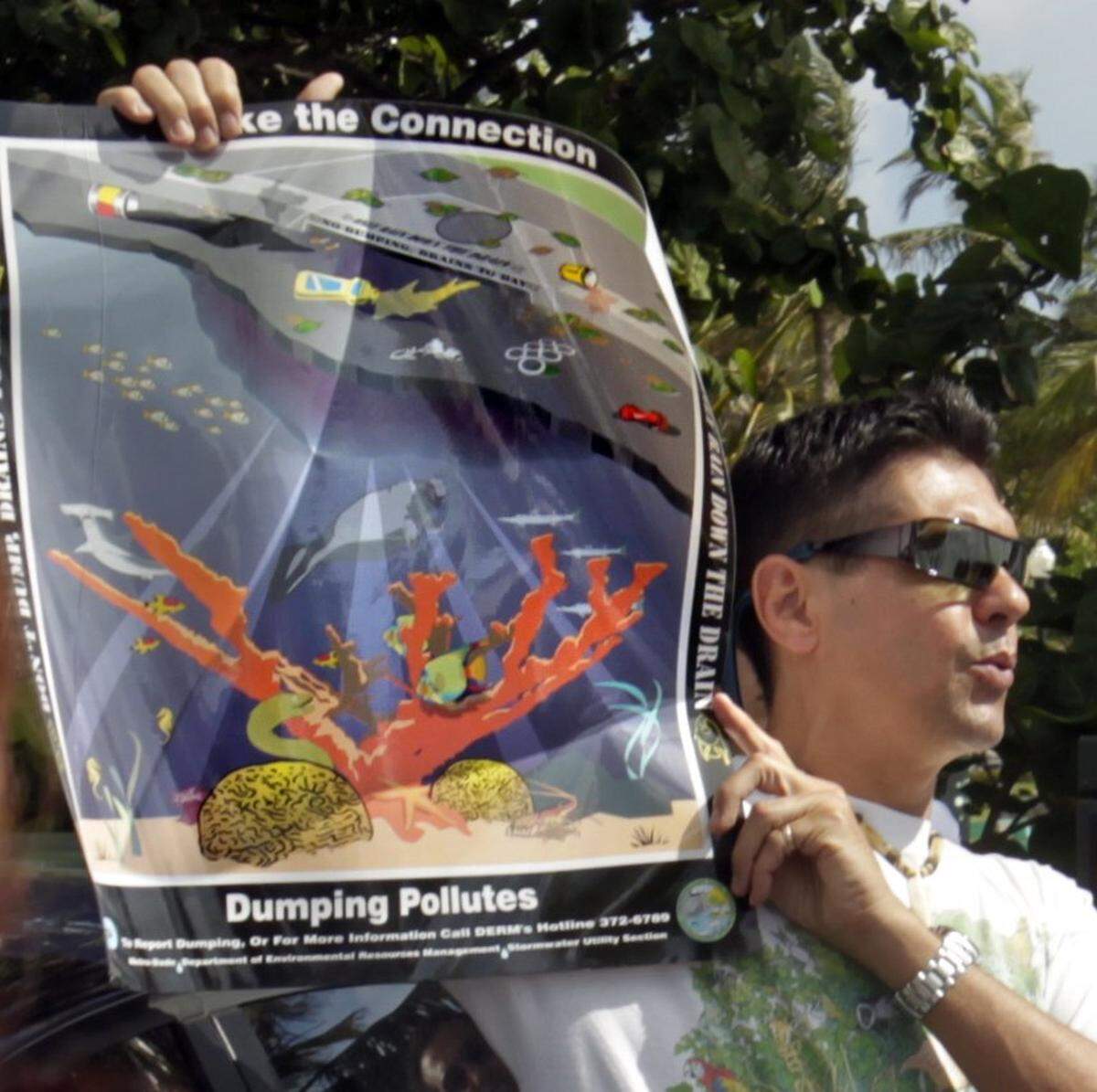 Luis Rodriguez, director ejecutivo de Environmental Coalition of Miami & the Beaches, muestra un póster sobre la contaminación en los mares.