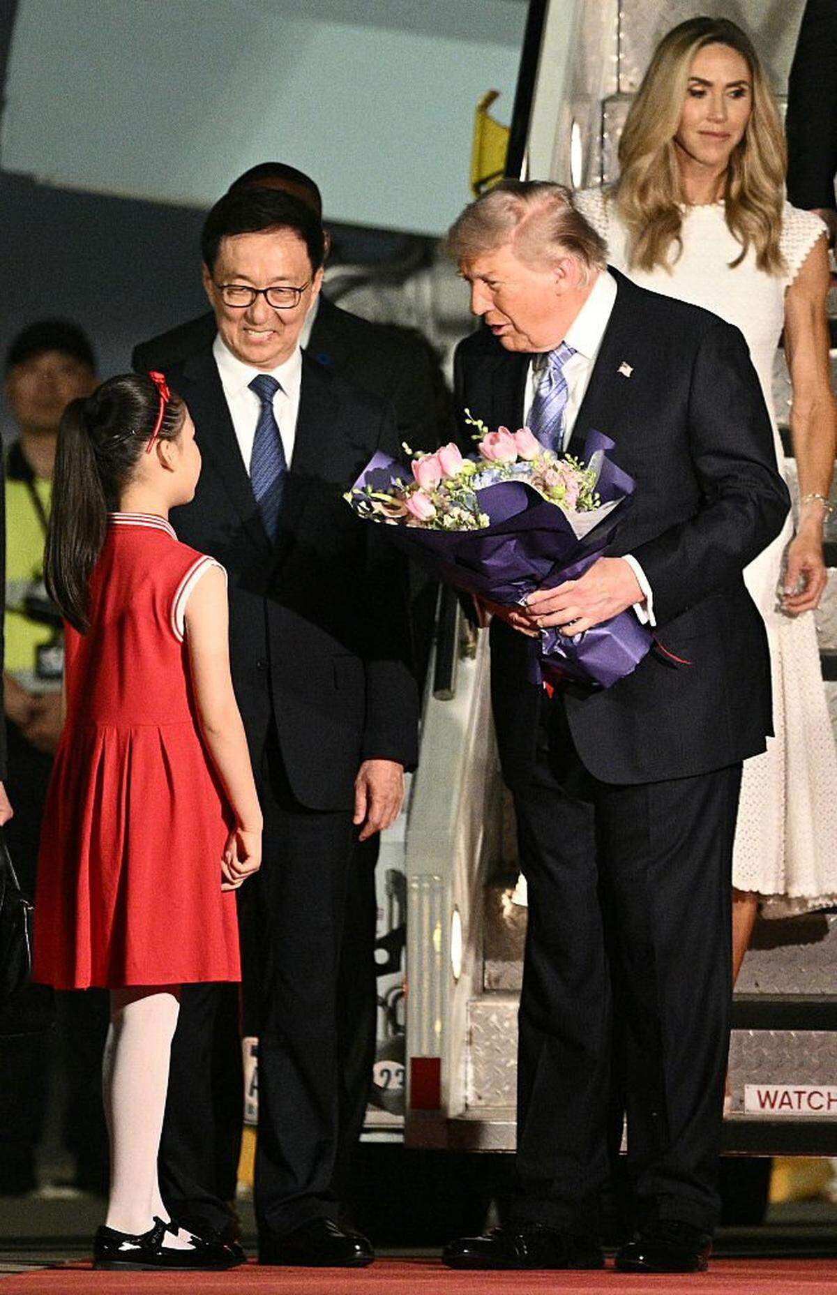 El presidente de Estados Unidos, Donald Trump, recibe flores a su llegada al Aeropuerto Internacional de Pekín-Capital, en Pekín, el 13 de mayo de 2026.