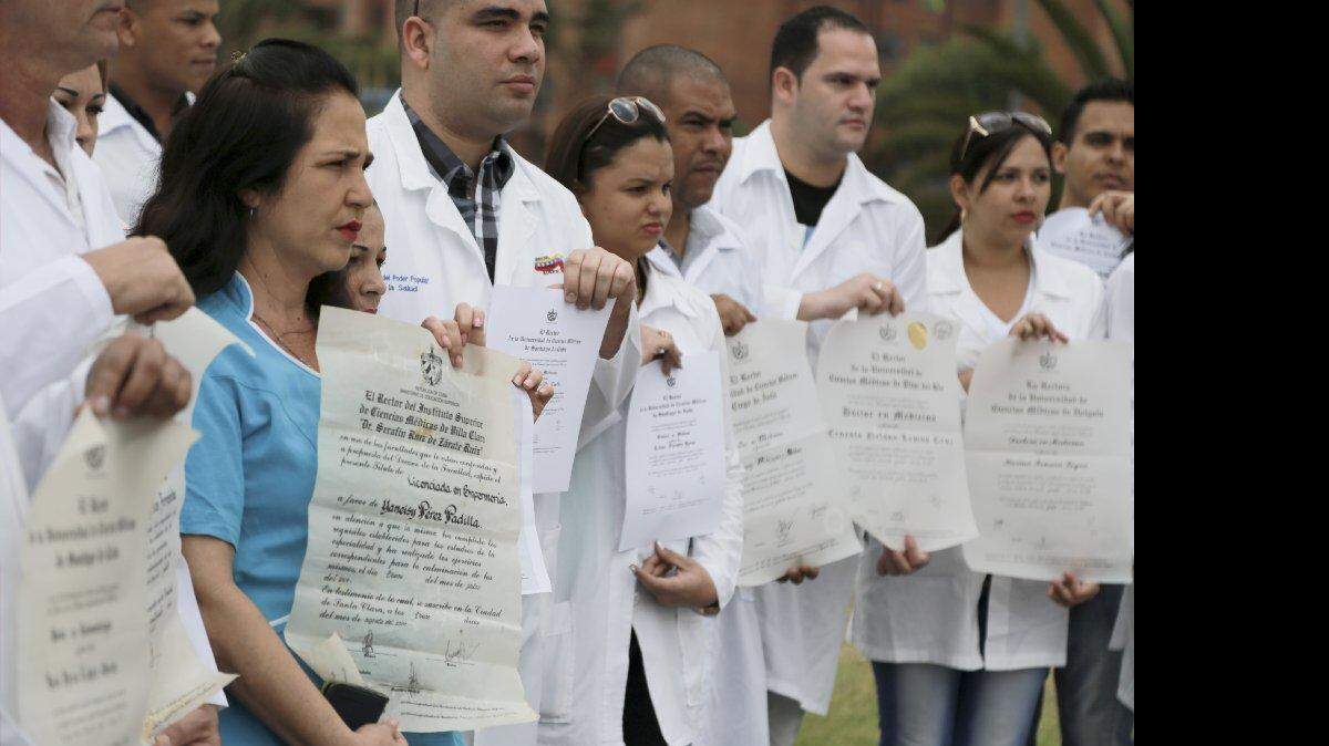 Yaneisy Pérez, izquierda, y otros médicos cubanos muestran sus diplomas durante una protesta para llamar la atención sobre su situación para conseguir visas para Estados Unidos en la plaza de Banderas en Bogotá, Colombia, el sábado 22 de agosto de 2015. Decenas de trabajadores de la salud que desertaron mientras sirviendo en misiones de ayuda en Venezuela huyeron a Bogotá esperando obtener con rapidez las visas a los Estados Unidos bajo el Programa de Libertad Condicional para los Médicos Profesionales Cubanos, diseñado para ayudar a que los desertores de la misión médica cubana encuentren refugio en EEUU, pero muchos se quejan de que han estado esperando durante meses sin una respuesta.