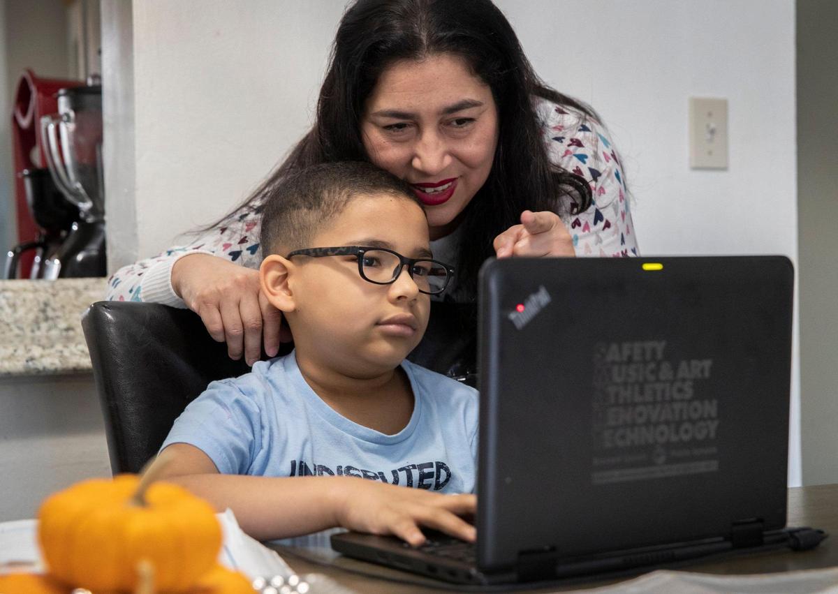 Rosana Ponte de Lara helps her son Francisco with virtual classes in the family’s apartment in Tamarac. Francisco could not get treatment for leukemia in Venezuela, so the family moved to Florida where he got access to treatment within days.