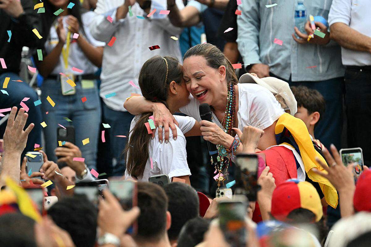 La líder opositora venezolana María Corina Machado abraza a una niña mientras se dirige a la diáspora venezolana durante un mitin en la Ciudad de Panamá, el sábado 23 de mayo de 2026.