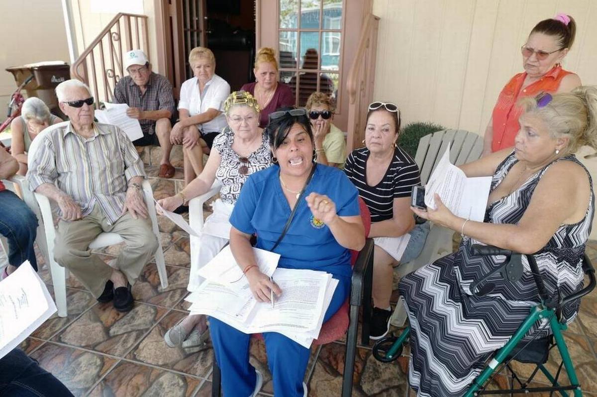 Naimy Vasconsello (centro, vestida de azul) junto a un grupo de vecinos, hablan con el Nuevo Herald sobre su inminente salida del campo de casas móviles porque los nuevos dueños del terreno quieren darle otro uso. Esta imagen fue tomada el 10 de abril del 2018 en el Sunny Gardens Mobile Park de Hialeah.