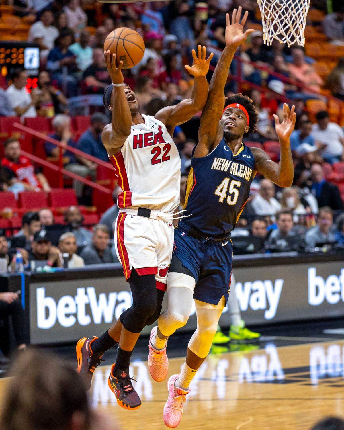 El jugador del Heat Jimmy Butler (izq.) lanza al aro ante la marca de Zylan Cheatham, de los Pelicans de New Orleans, en el partido de pretemporada celebrado el 12 de octubre de 2022 en Miami.