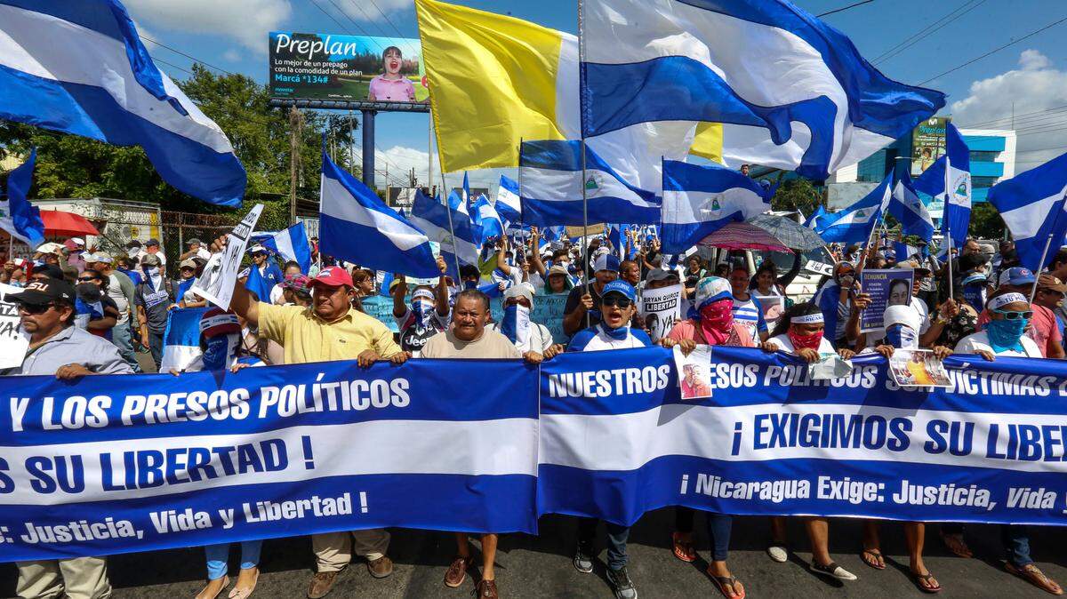 Manifestantes marchan con banderas de Nicaragua en una protesta contra el gobierno de Ortega y su esposa Rosario Murillo el 11 de agosto del 2018 en Managua.