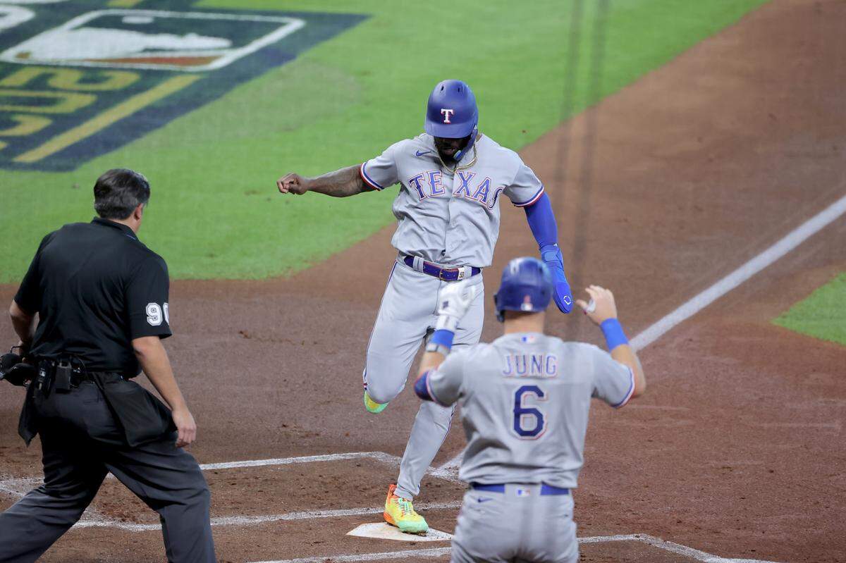 El jardinero de los Rangers de Texas Adolis García anota una carrera en el primer inning contra los Astros, en el segundo juego de la Serie de Campeonato de la Liga Americana, celebrado el 16 de octubre de 2023 en Houston.