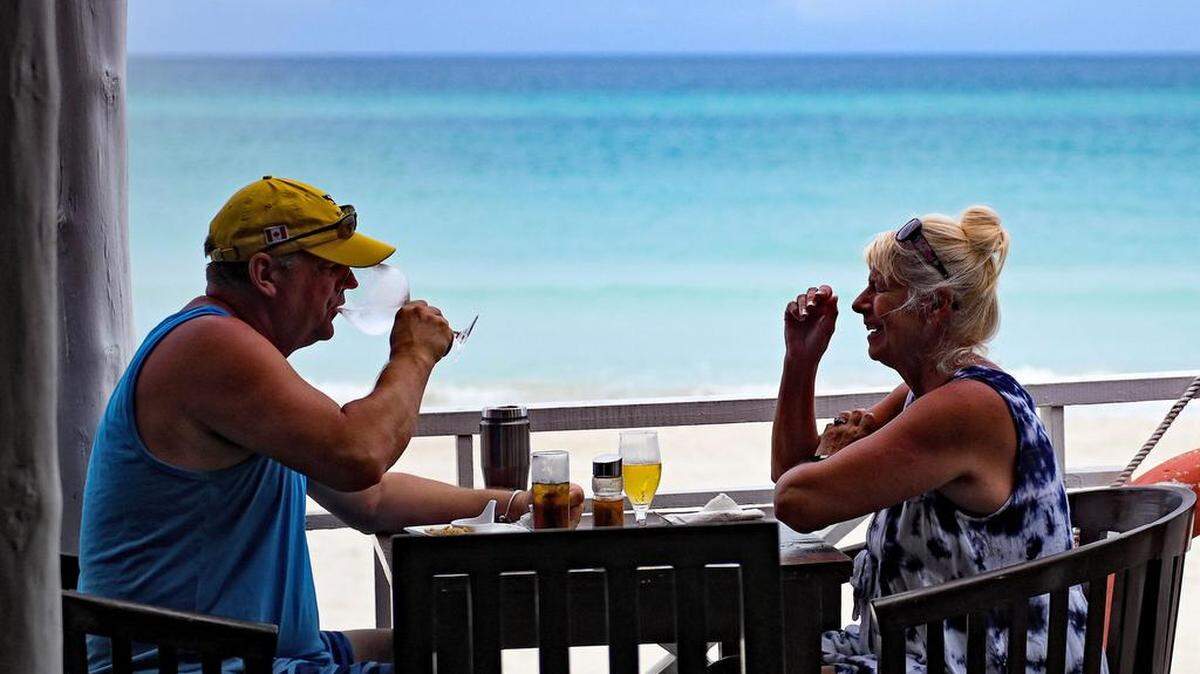 Turistas consumen bebidas mientras disfrutan del día en Varadero, provincia de Matanzas, Cuba, el 22 de octubre de 2021.