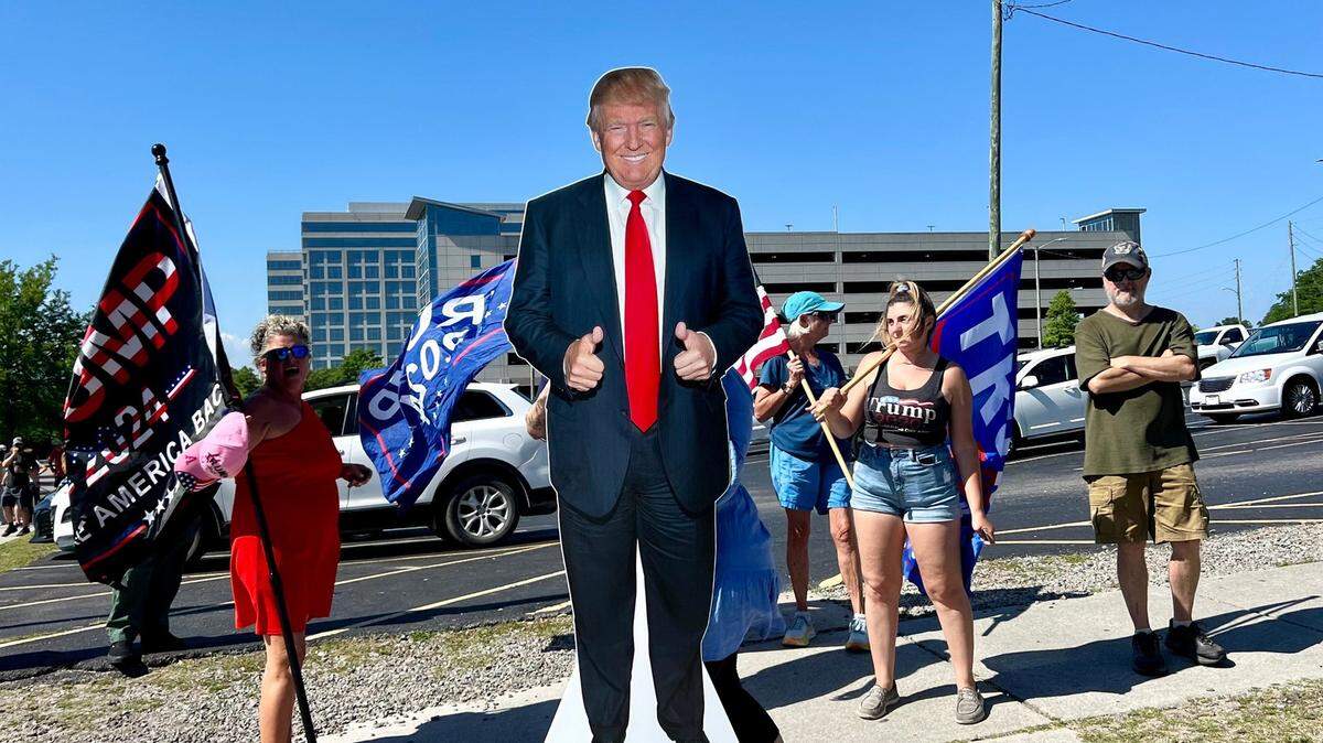Seguidores del expresidente Donald Trump cargan una imagen de cartón del candidato cerca del Centro de Convenciones de Wilmington, Carolina del Norte, el jueves 2 de mayo de 2024.