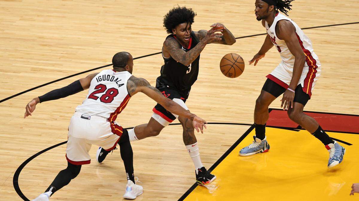 El jugador de los Rockets de Houston Kevin Porter Jr. (3) pierde la pelota ante la marca de Andre Iguodala (28) y Precious Achiuwa, del Heat, en el primer cuarto del partido celebrado el 19 de abril de 2021 en Miami.