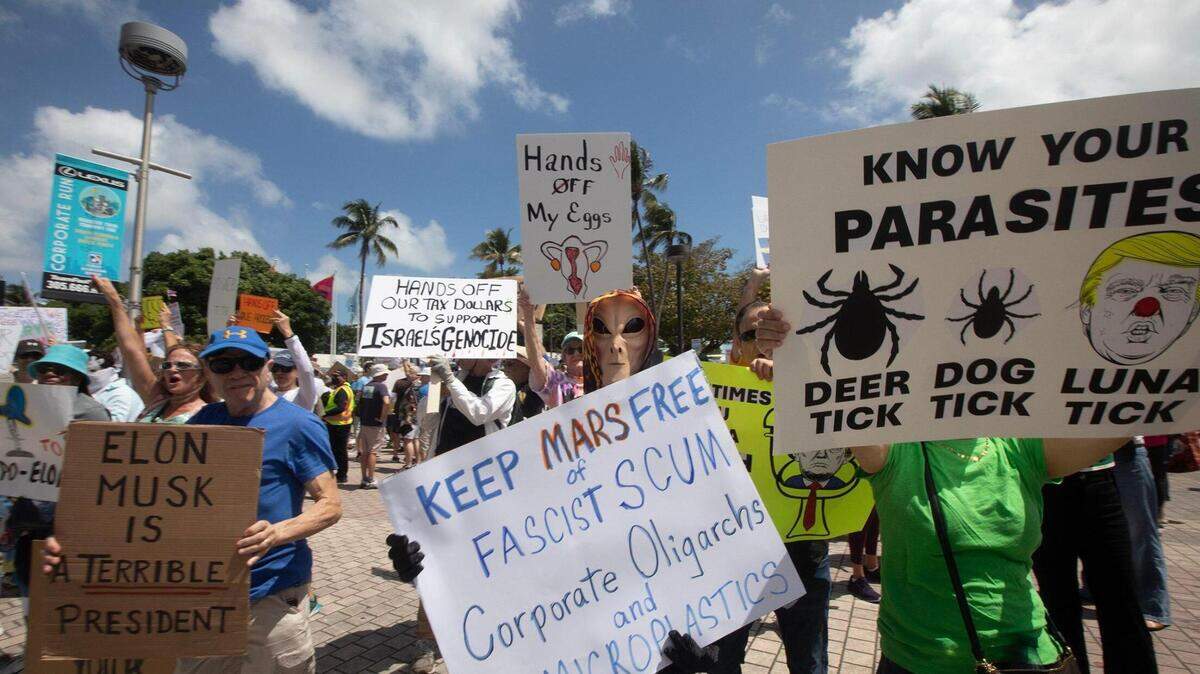 Manifestantes se congregaron ante la Antorcha de la Amistad en el downtown el sábado durante la manifestación “¡Manos Fuera! Miami Contraataca”, en oposición a las políticas del presidente Donald Trump y su asesor, Elon Musk.