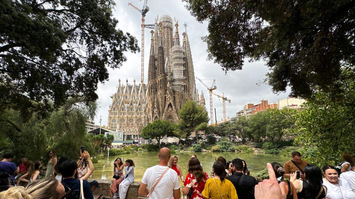 Turistas posan para fotos y otros observan la Basílica de la Sagrada Familia en Barcelona, España, el 19 de junio de 2024. Los residentes de Barcelona creen que la masificación del turismo ha hecho que la ciudad sea menos asequible.