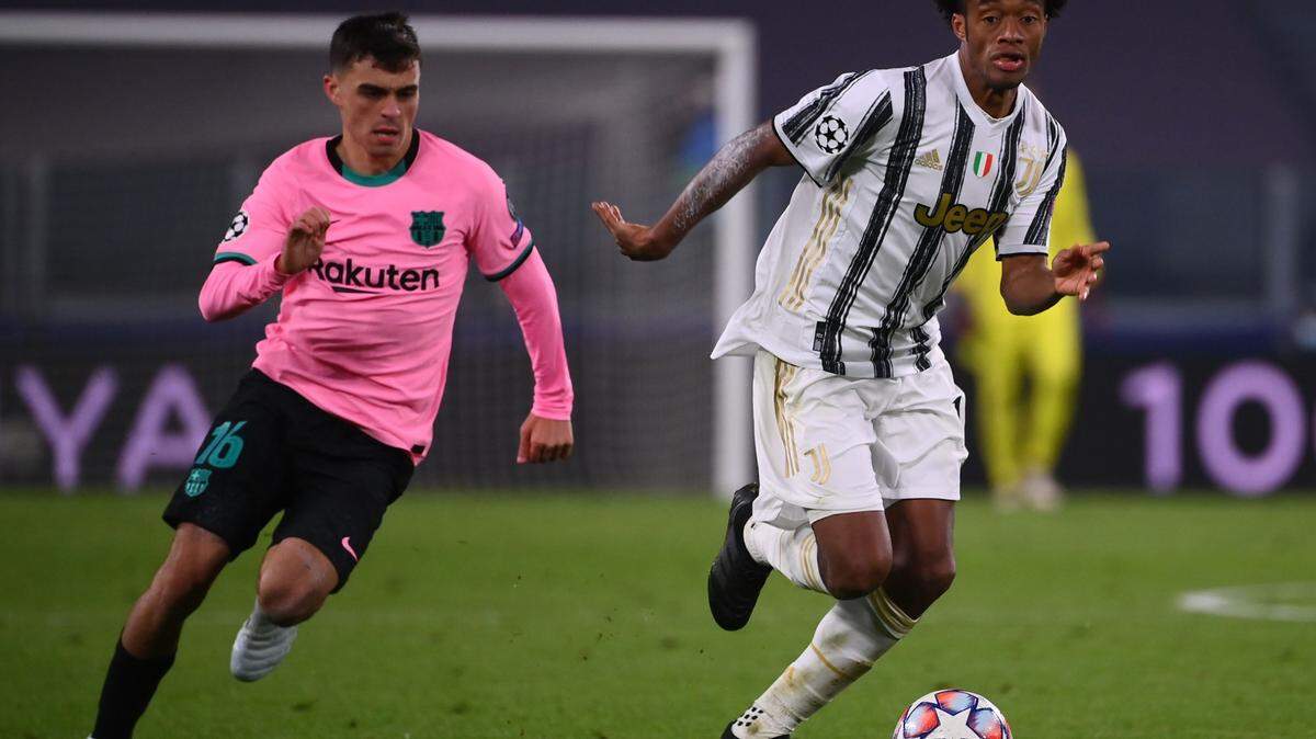 El mediocampista colombiano de la Juventus, Juan Cuadrado, pelea por el balón con el mediocampista español del Barcelona, Pedri, durante el partido de fútbol del Grupo G de la Liga de Campeones de la UEFA entre la Juventus y el Barcelona el 28 de octubre de 2020 en el estadio de la Juventus en Turín.